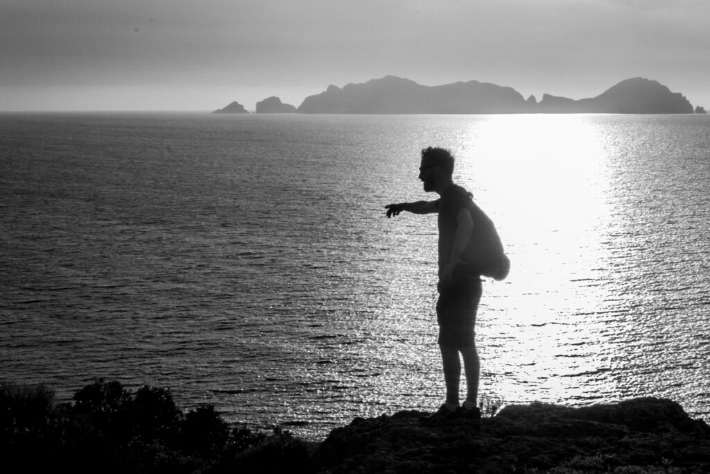 a silhouette man with the sea at the background