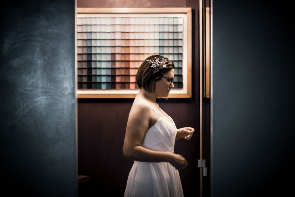 Young bride with wedding dress looks at the mirror during the preparation