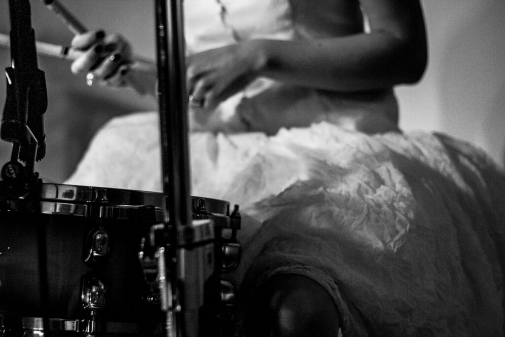 details of a woman with wedding dress while playing drums