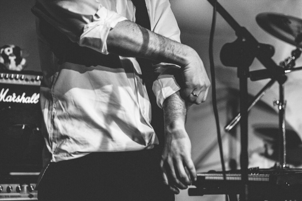 an elegant man dressed while lifting the sleeve of the white shirt