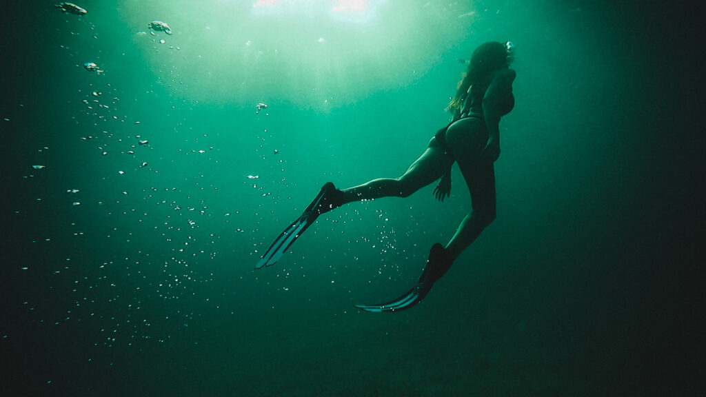 woman diving on the green deep water, underwater dream